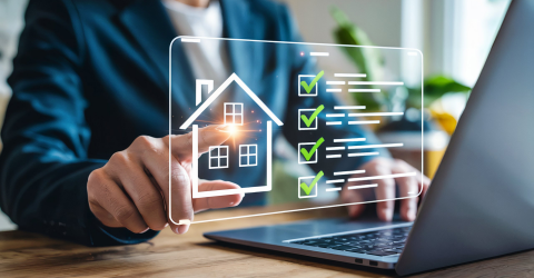 Man achter een laptop met een pop-up van een silhouet van een huis en een checklist